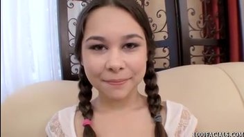 Миниатюрная девушка с косичками сосет перед камерой